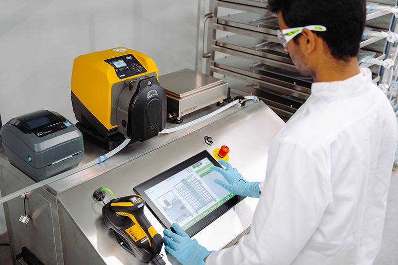 A close-up image of an operator handling an aseptic filling system for single-use bags.