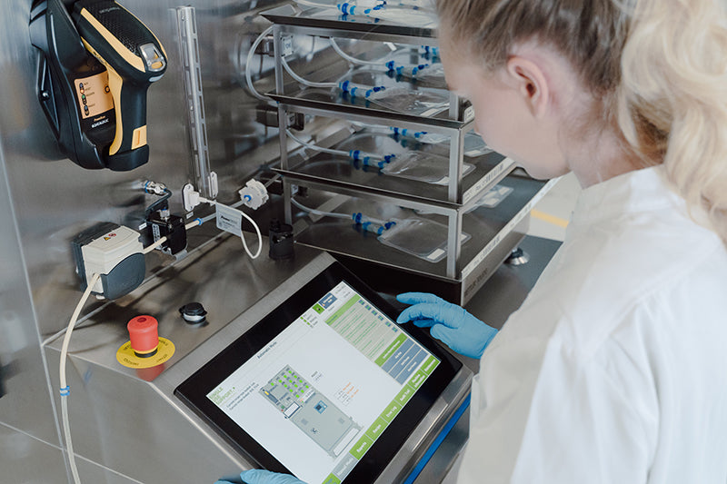 Close-up of an operator handling small-volume drug substances on a RoSS.FILL CGT aseptic filling system.