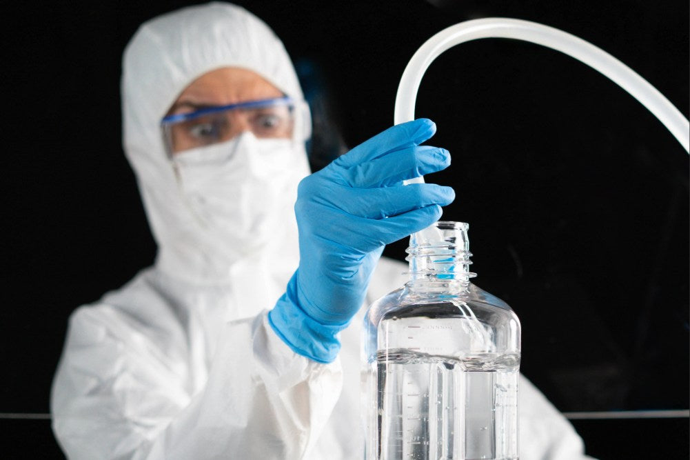 An operator fills a biopharma bottle with antibody-drug conjugates manually, resulting in insecurities and inaccuracies 