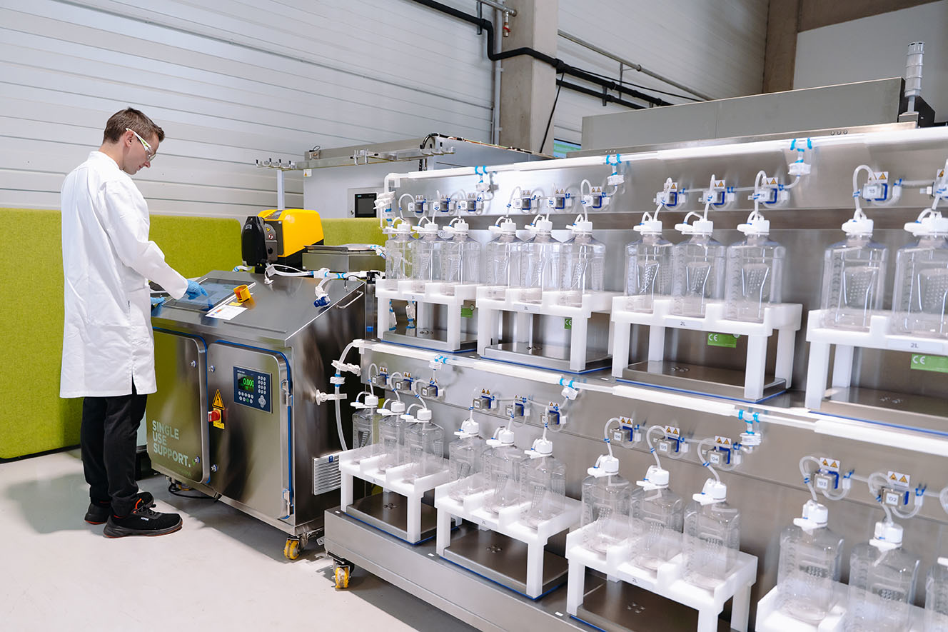 Person in a lab coat overserving an automated fill run of bottles with RoSS.FILL Bottle