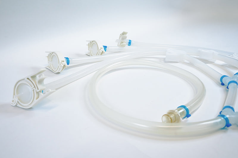 Clear medical tubing with connectors on a light gray background
