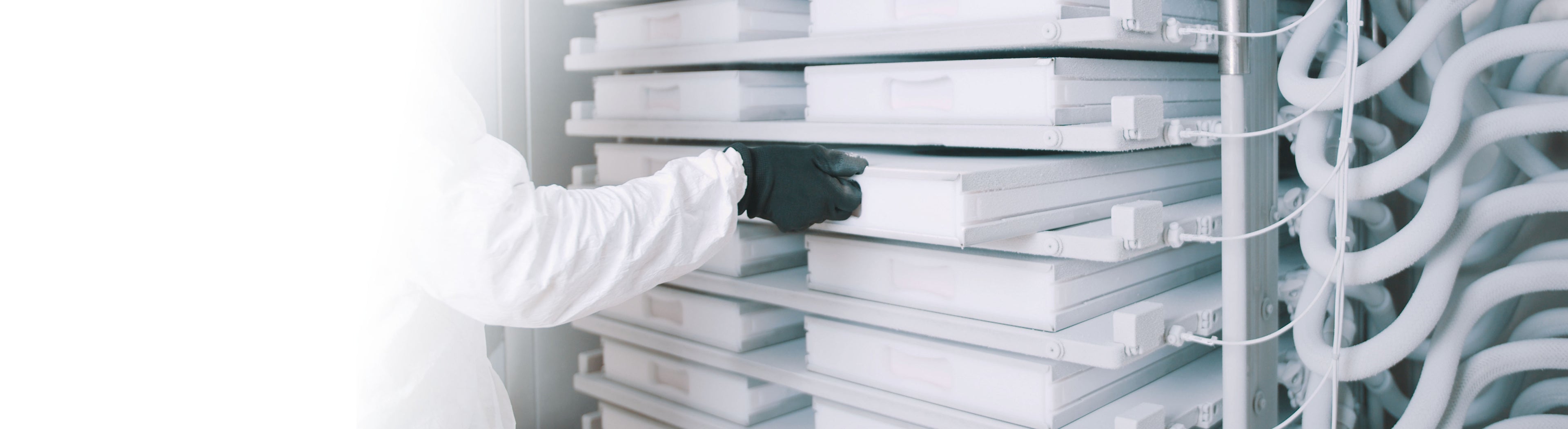 Person with a white coat sliding a RoSS shell into the RoSS.pFTU plate freezer