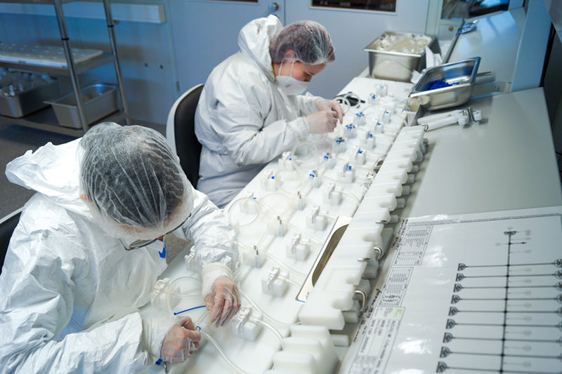 An image of the IRIS production line showing two Single Use Support employees creating custom single-use assemblies.