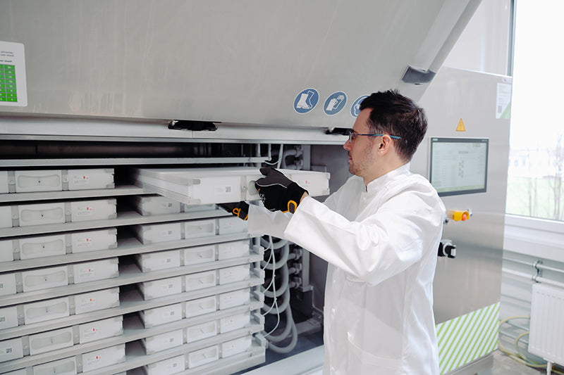 Mid-frame image of an operator placing RoSS shells into a RoSS.pFTU Large-Scale freeze-thaw unit.