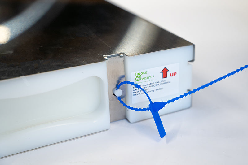 Close-up image of a RoSS shell with  a blue cable seal to secure that RoSSshe ll has remaine a closed system throughout storage and shipping.